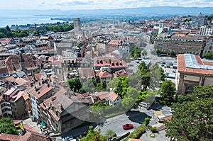 The red roofs of medieval buildings in the city center of Lausanne and the lake at the background