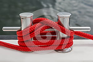 Red rope fasten on stake of yacht