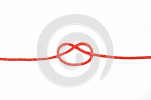Red rope with a knot not completely tied on a white isolated background