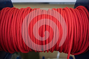 The red rope is reeled up on the coil in shop. A saving or safety rope for climbers