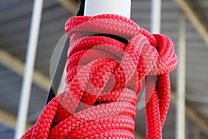 Red Rope tied in complex knot around pole at Dock