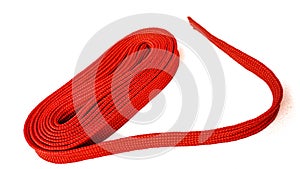 Red rope on white background. Fabric rope in red color folded in a coil