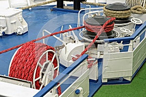Red ropes in bobbins on the blue deck