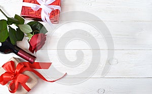 Red rose, a bottle of wine and gifts.