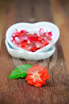 Red rose and ceramic heart shape on old wooden