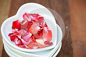 Red rose and ceramic heart shape on old wooden