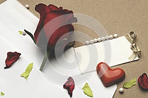 Red rose in an envelope on a light brown background