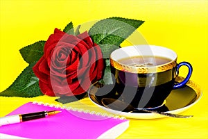 Red rose flower, Cup of tea healthy drink, Notepad and pen for writing text.