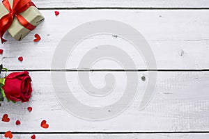Red rose flower, hearts and gift box on white wood table with copy space for top view valentine and romance concept