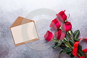 Red rose flowers bouquet, envelope on stone background Valentine`s day greeting card Copy space