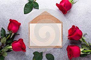 Red rose flowers bouquet, envelope on stone background Valentine`s day greeting card Copy space