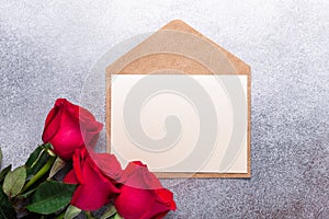Red rose flowers bouquet, envelope on stone background Valentine`s day greeting card Copy space