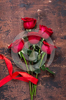 Red rose flowers bouquet on wooden background Valentine`s day greeting card Copy space Top view