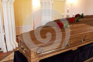 Red rose flowers on wooden coffins in church