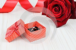 Red rose and gift box with golden ring
