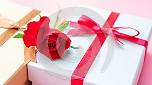 Red rose and gift box on a pink background