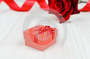 Red rose and gift box on a wooden table