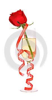 Red rose in glass of champagne and paper streamer.