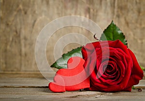 Red rose with handemade valentines on wooden background