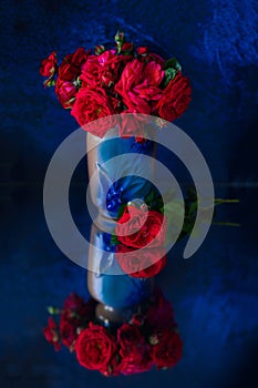 Red rose hip in a blue vase