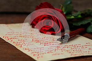 Red rose and an ink pen on a letter