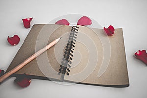 Red rose with petals and brown notebook for valentine background isolated on white background