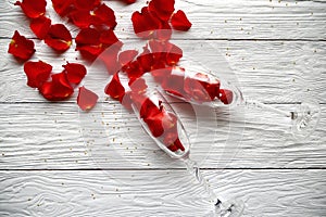 Red rose petals spilled out of wine glasses.