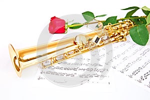 Red rose, saxophone and music sheet