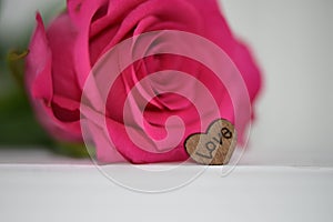 Red rose with wooden love heart shape