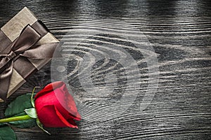 Red rose wrapped gift box on wooden board celebrations concept