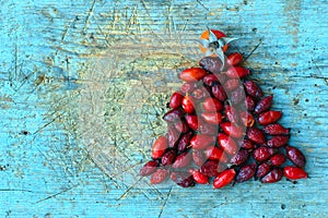 Red Rosehips On Blue Wooden Background photo