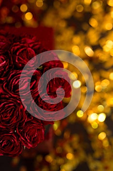 Red roses in a black gift box on golden background. Burgundy roses for mother's day. Flowers on March 8. Happy