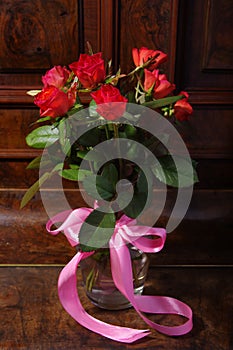 Red roses bouqet on the vintage old wooden piano photo