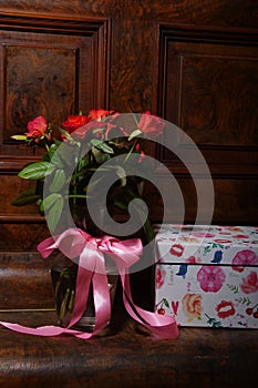 Red roses bouqet on the vintage old wooden piano photo