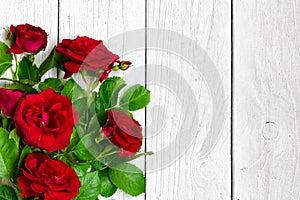 Red roses bouquet over white wooden table. valentines day or womens day background