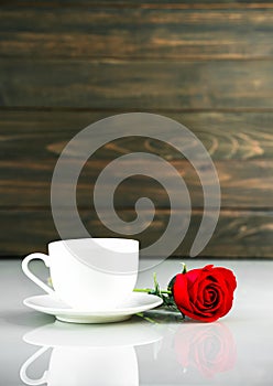 Red roses and coffee cup on table with copy space