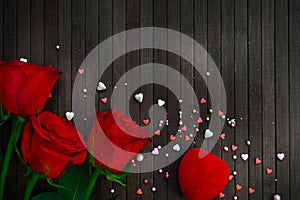 Red roses on a dark wooden background, a gift in the form of a heart. Valentine`s Day concept. March 8. Mothers Day