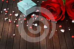 Red roses on a dark wooden background, a gift a heart. Valentine`s Day concept. March 8. Mothers Day.