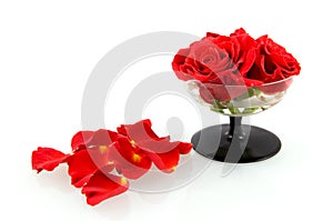 Red roses in glass with rose leaves