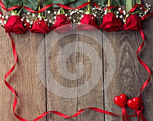 Red roses with ribbon frame and two hearts