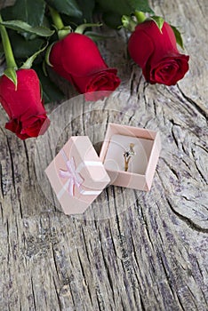 Red roses with wedding ring