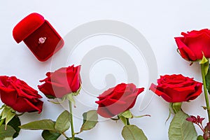 Red roses on a white background and wedding ring