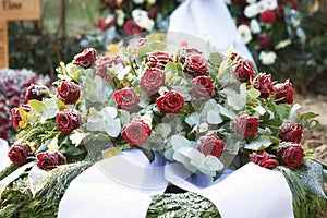 red roses with white ribbons as funeral flowers