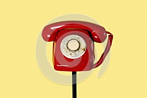 red rotary dial telephone on a stand