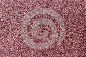 Red rough surface of sandpaper close up