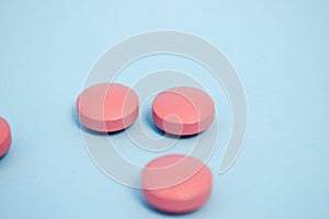 Red round medical pharmaceutical pharmaceuticals for the treatment of diseases pills medicines on a blue background