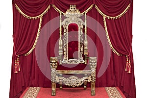 Red royal chair on a background of red curtains.