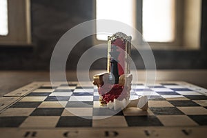 Red royal chair miniature on wooden table. Medieval Throne on chessboard. Chess board game concept of business ideas and