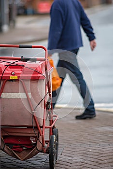 Red royal mail trolley chained to gate