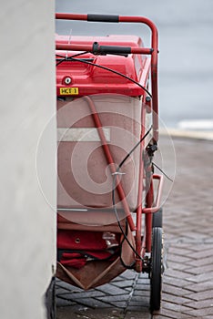 Red royal mail trolley chained to gate